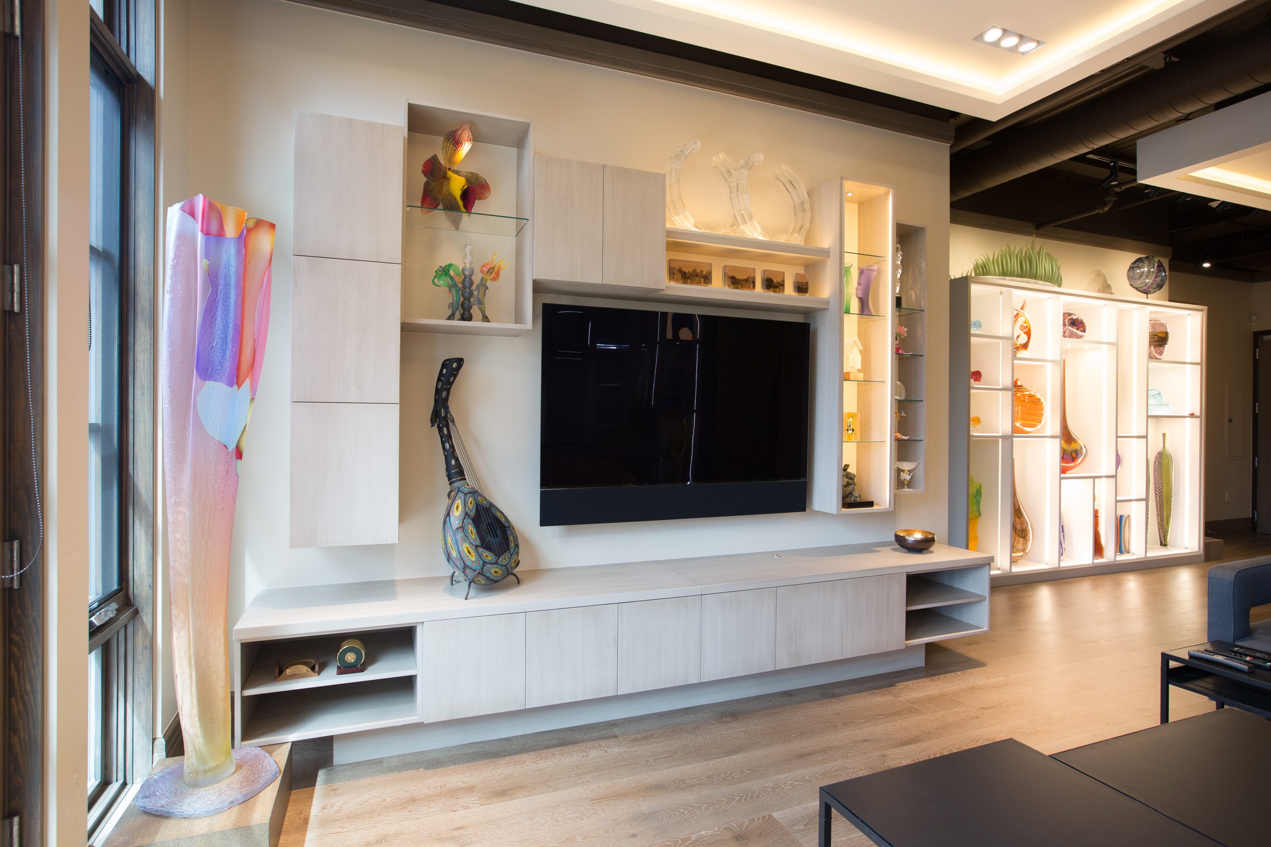 Living room with custom built-in shelving, display niches and media cabinetry